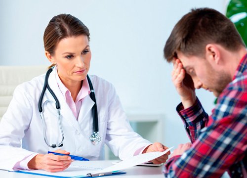 Врач с пациентом сидят за столом